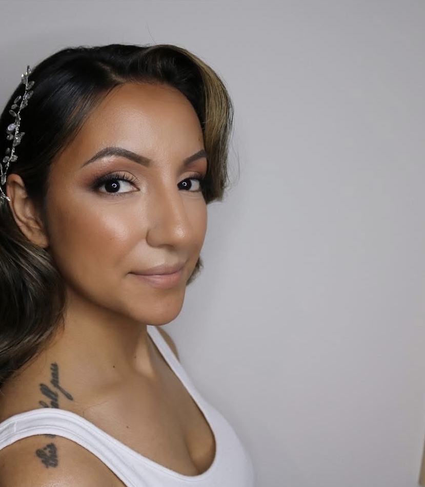 A woman posing, showing off her bridal makeup.