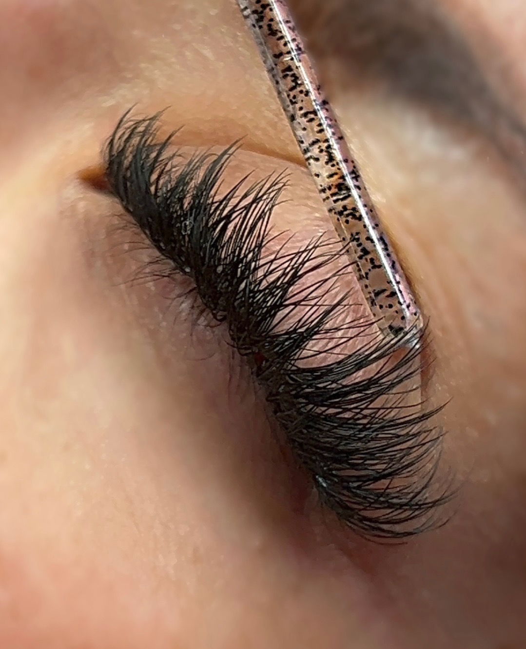 A close-up of a womans eye, showing off her new colored lash extensions.