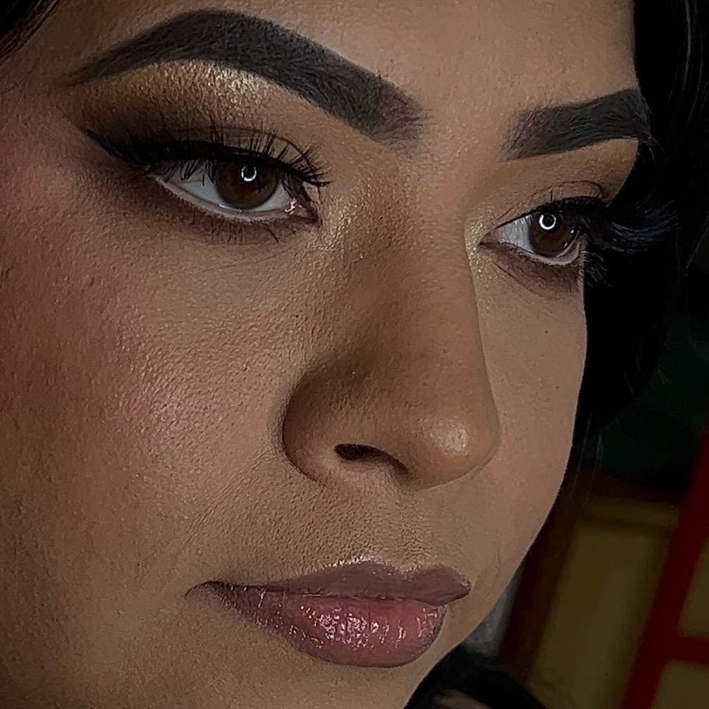 A woman posing, showing off her soft glam makeup.