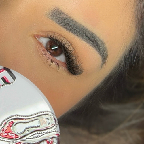 A photo of a woman laying down, showing off her new lash extensions.