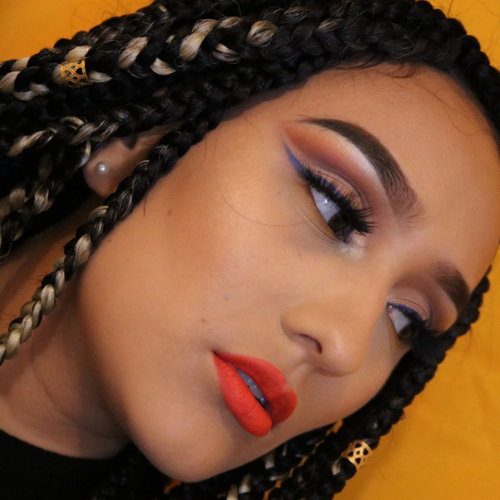 A woman posing as she shows off her newly done glam makeup.