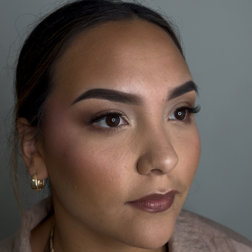A woman posing as she shows off her newly done soft-glam makeup.