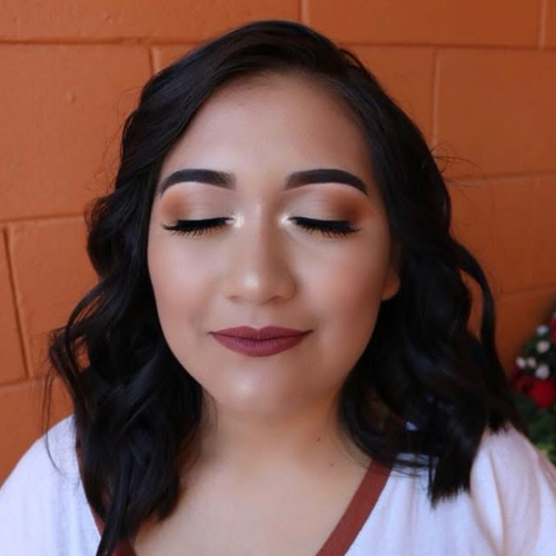 A woman posing as she shows off her newly done soft-glam makeup.