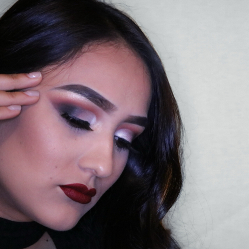 A woman posing as she shows off her newly done glam makeup.