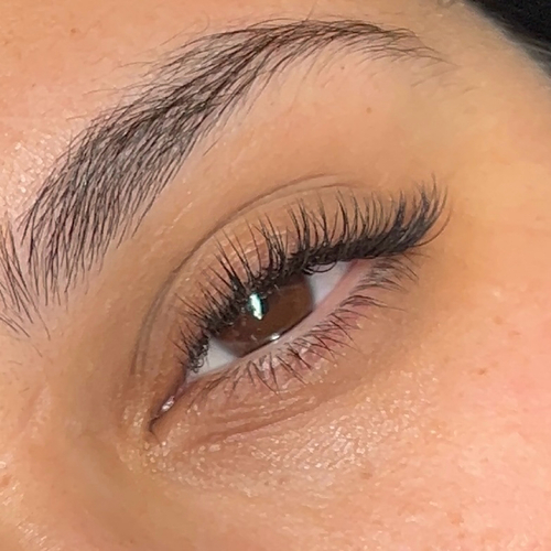 A woman looking into the camera showing off her new classic lash extensions.