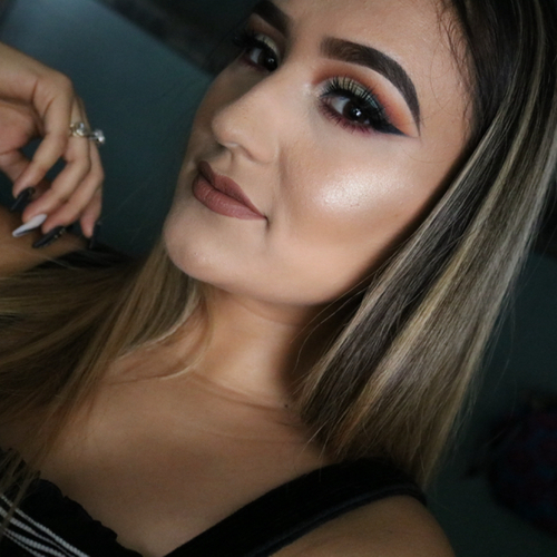 A woman posing as she shows off her newly done glam makeup.